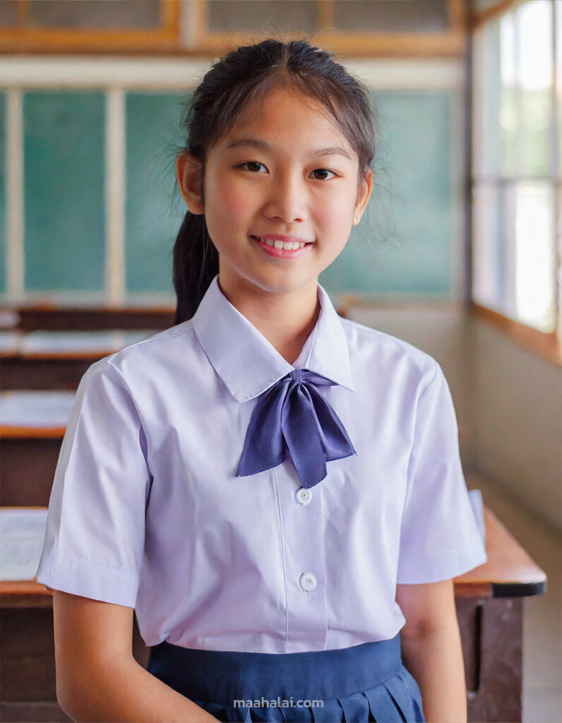 ภาพถ่ายครึ่งตัว ผู้หญิงไทยอายุ 17 ปี ใส่ชุดนักเรียนอยู่ในห้องเรียน