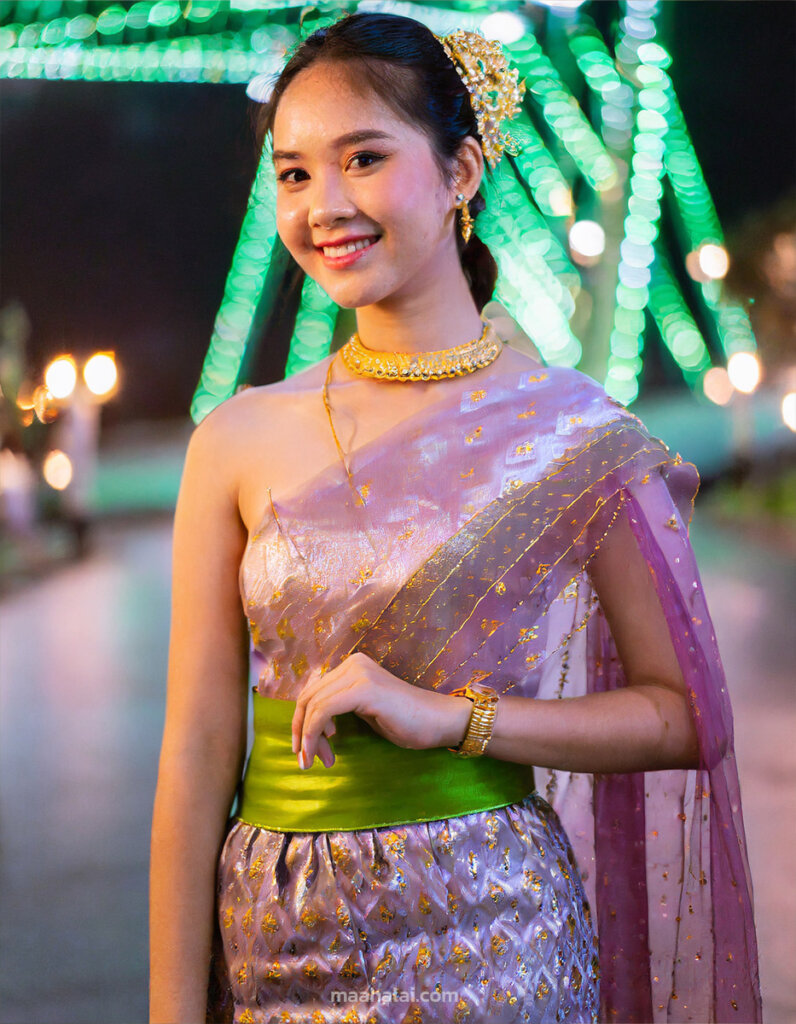 ภาพถ่ายครึ่งตัว นางแบบหญิงไทยอายุ 18 ปี ใส่ชุดไทย อยู่เมืองที่มีแสงนีออน